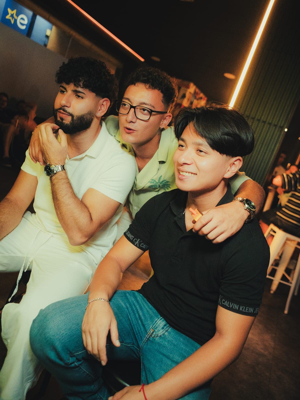 Tres amigos abrazados posando para la cámara