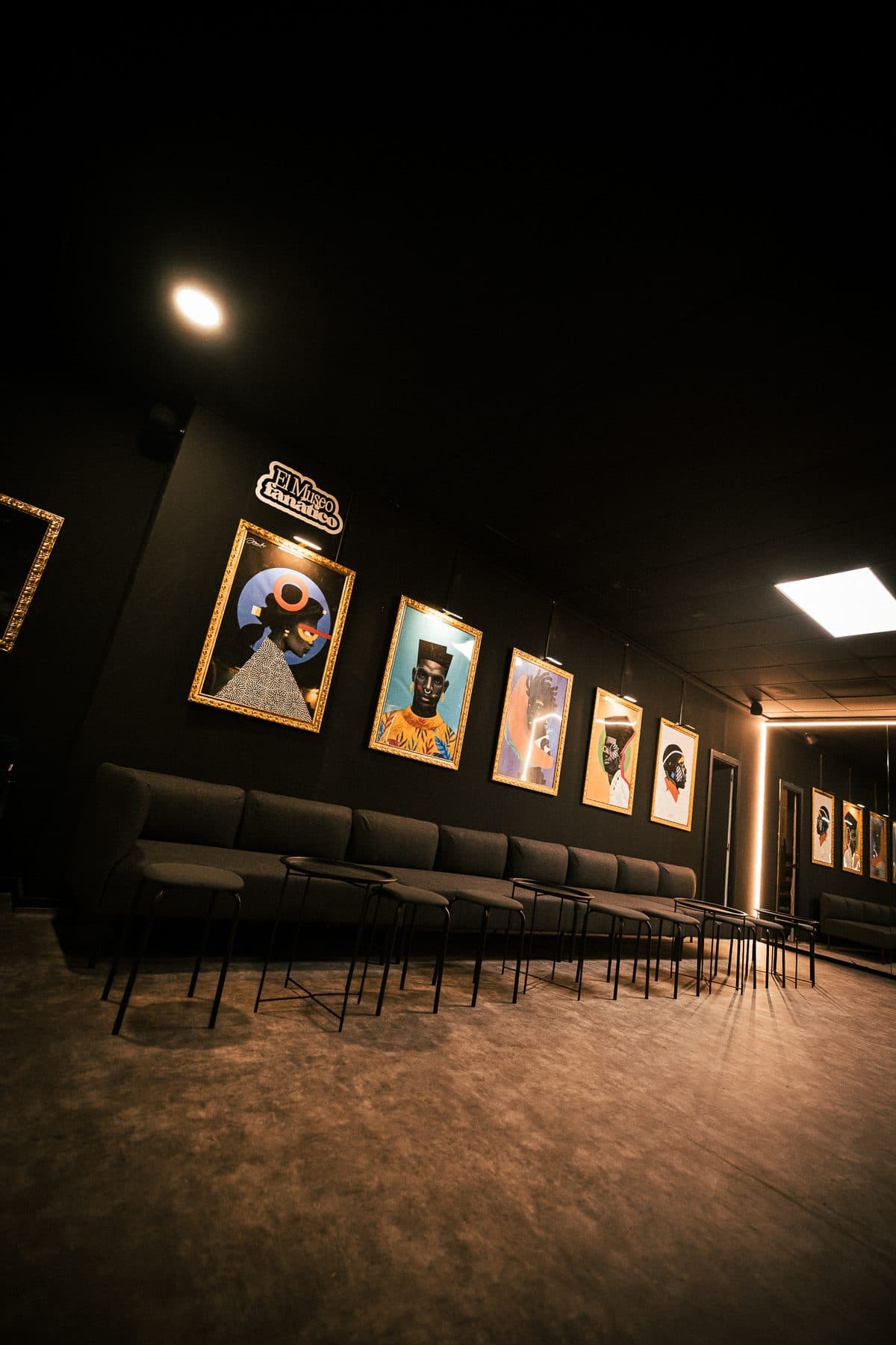 La sala del museo con el rótulo «El Museo Fanático» y la fila de cuadros iluminados
