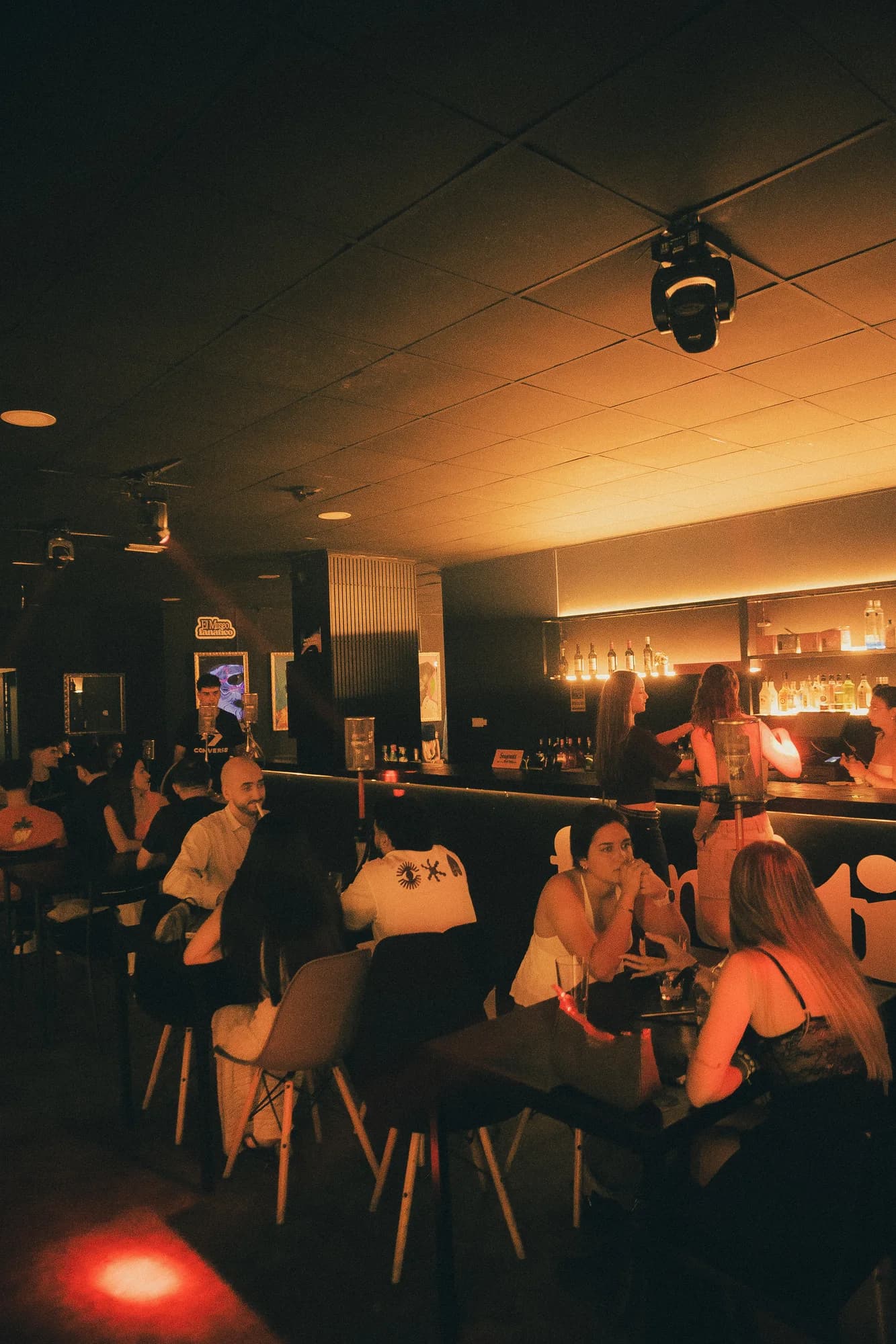 Un grupo de amigos sentados bajo los cuadros dorados de la sala