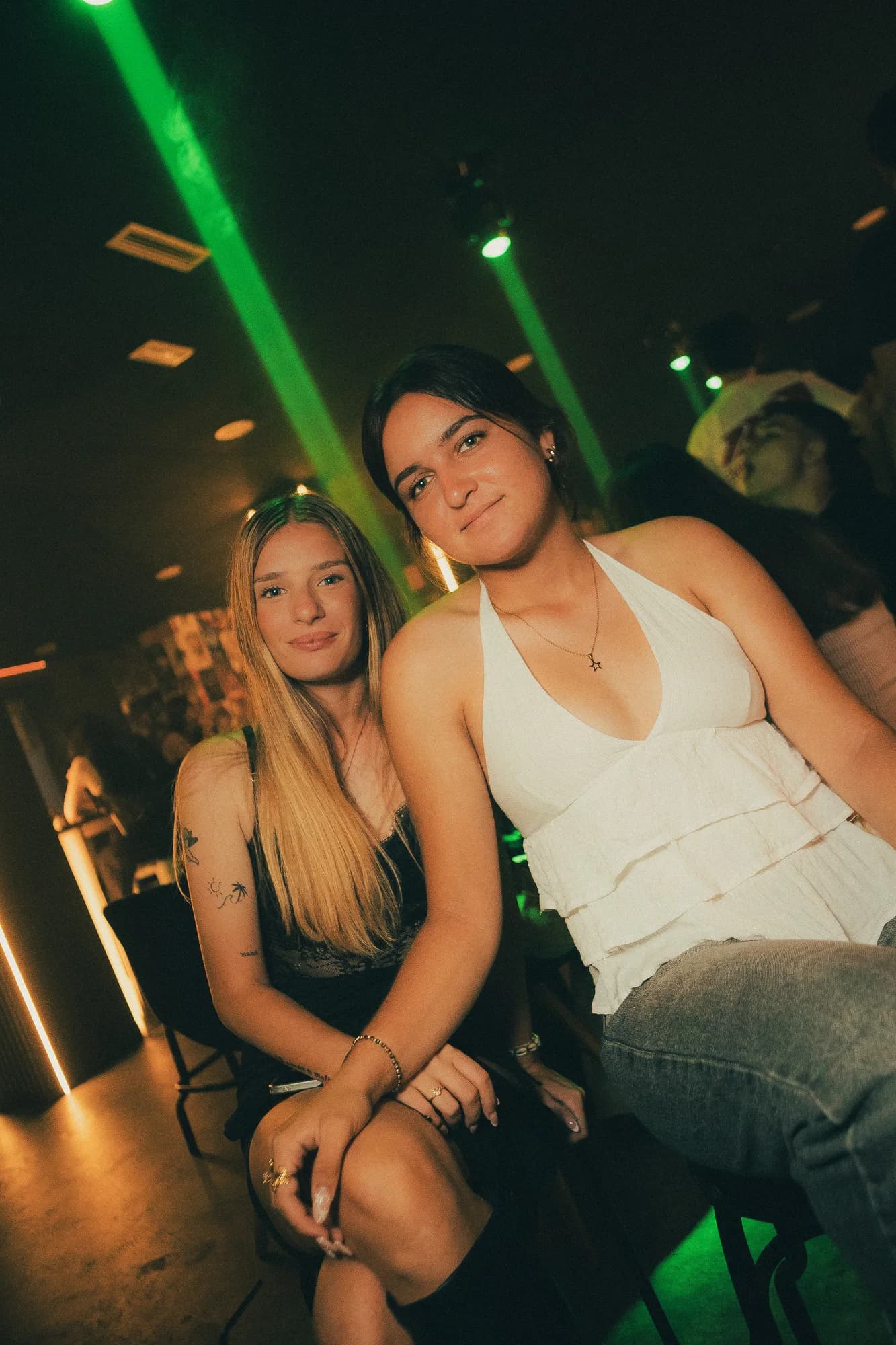 Dos amigas delante de la pared de carteles de cine